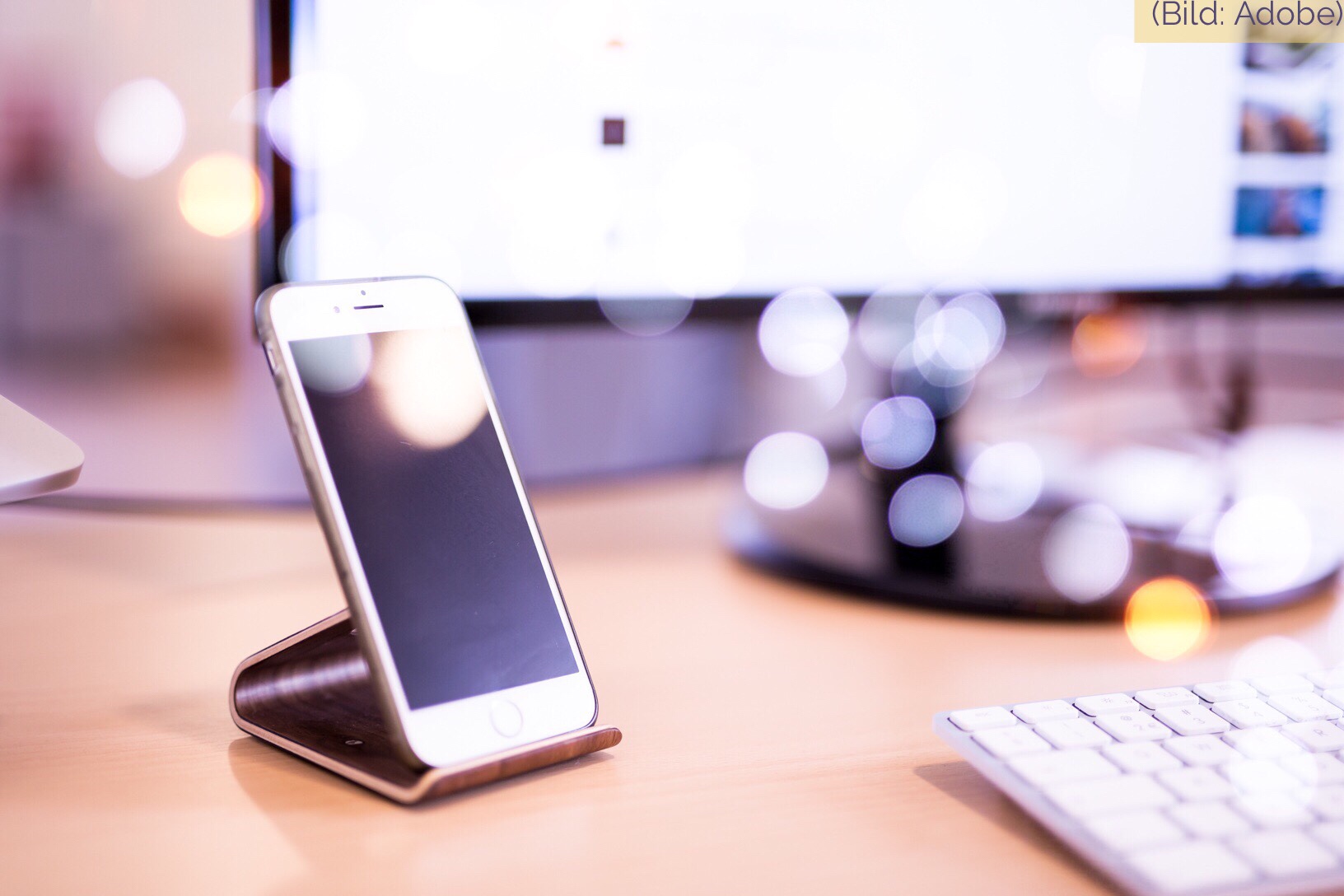 iPhone on a stand on the desk – symbolic of Apple's battery replacement and battery refund program.