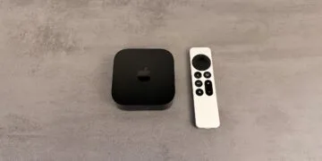 Setting up Apple TV: black Apple TV 4K next to a silver Siri Remote on a grey stone-look surface