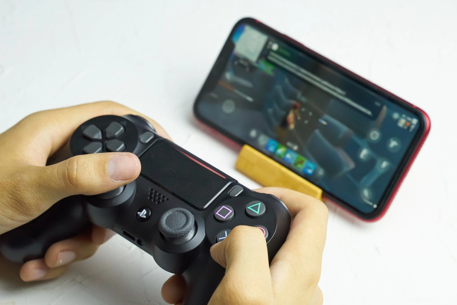 Bishkek, Kyrgyzstan - June 06, 2019: Man playing games on Apple arcade subscription system on iOS 13 with Sony Dualshock gamepad