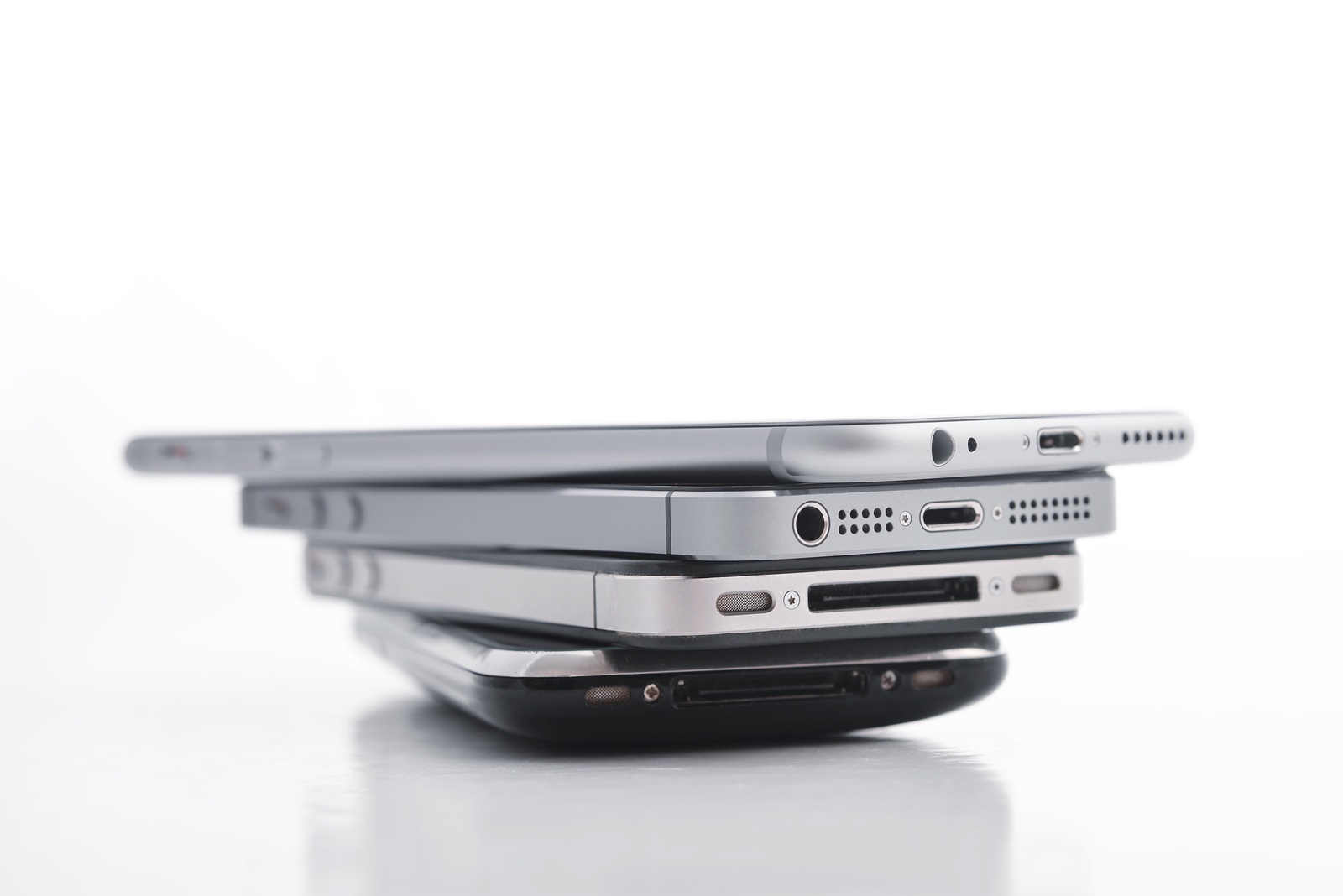Kiev Ukraine - March 05 2016: Pile of Apple iPhone 5s Apple iPhone 6 Apple iPhone 4 and Apple iPhone 3gs. Apple Inc. is an American multinational corporation that designs, develops and sells consumer electronics.