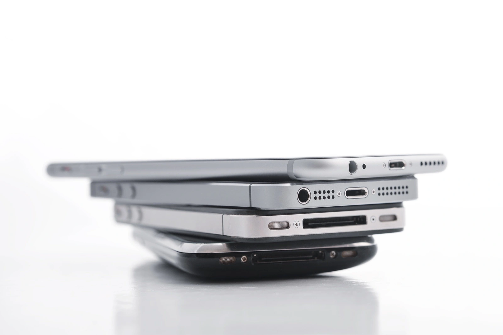 Kiev Ukraine - March 05 2016: Pile of Apple iPhone 5s Apple iPhone 6 Apple iPhone 4 and Apple iPhone 3gs. Apple Inc. is an American multinational corporation that designs, develops and sells consumer electronics.