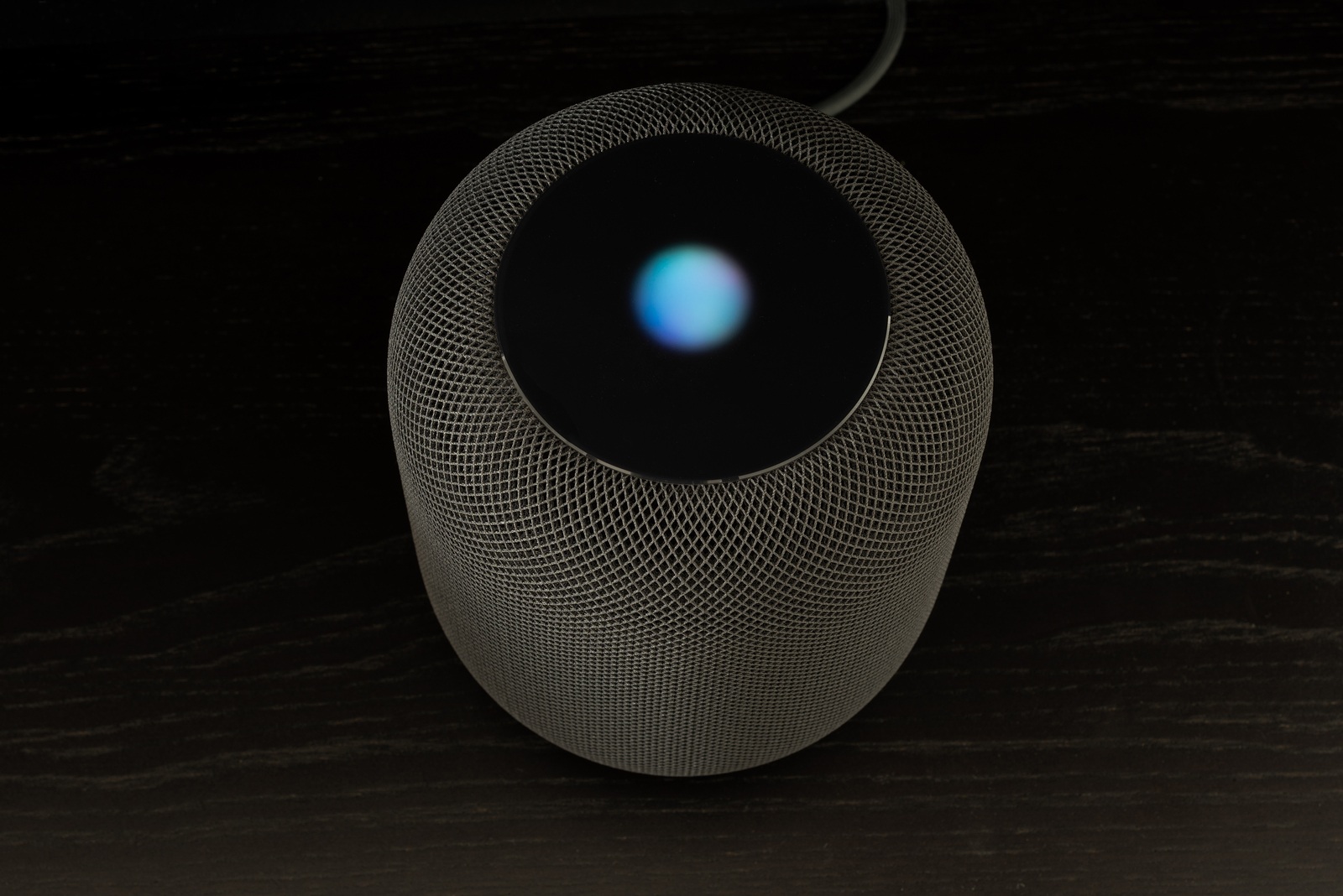 Ostfildern, Germany - June 26, 2018: Using an Apple HomePod speaker - the smart speaker is reacting to voice input and signaling its attention by the changing lights