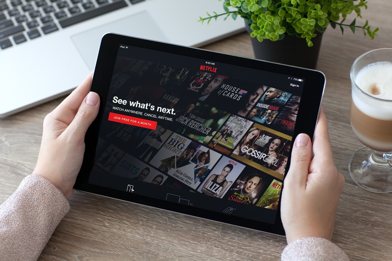 Alushta Russia - October 9 2016: Woman holding an iPad Pro Space Gray with multinational entertainment company Netflix provides streaming media and video on the screen. iPad Pro 9.7 was created and developed by the Apple inc.