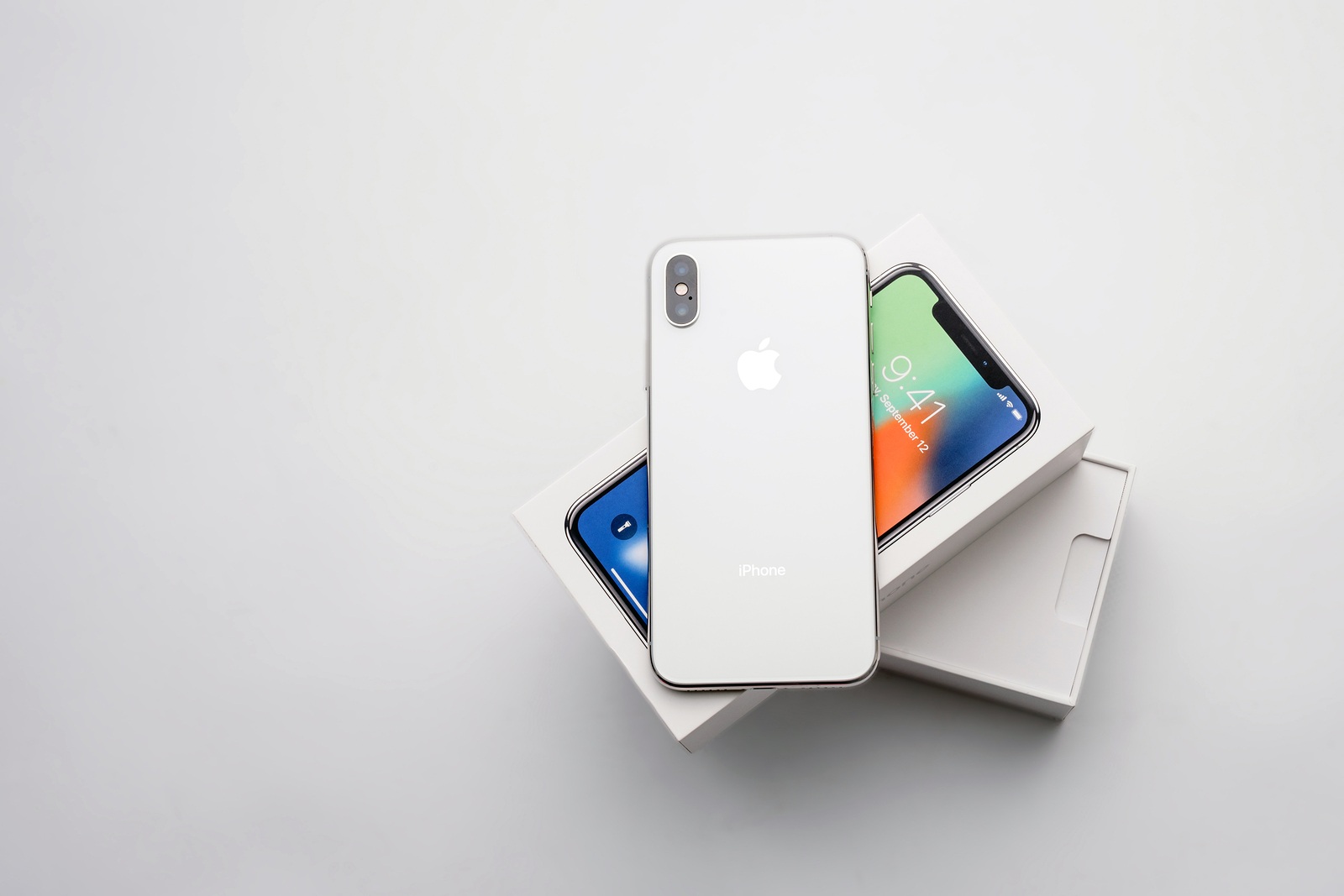 KYIV, UKRAINE - JANUARY 26, 2018: New Iphone X smartphone model close up. Newest Apple Iphone 10 mobile phone device on white branded Apple box on white table in store