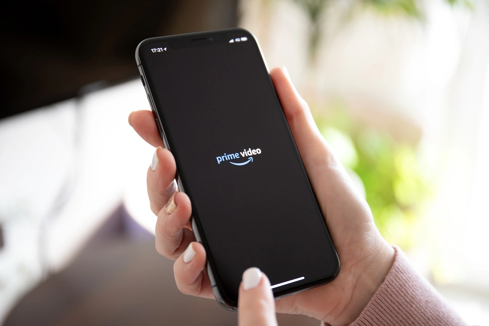 Anapa, Russia - February 20, 2019: Woman holding iPhone X with multinational entertainment company Amazon Prime Video provides streaming media and video on the screen.