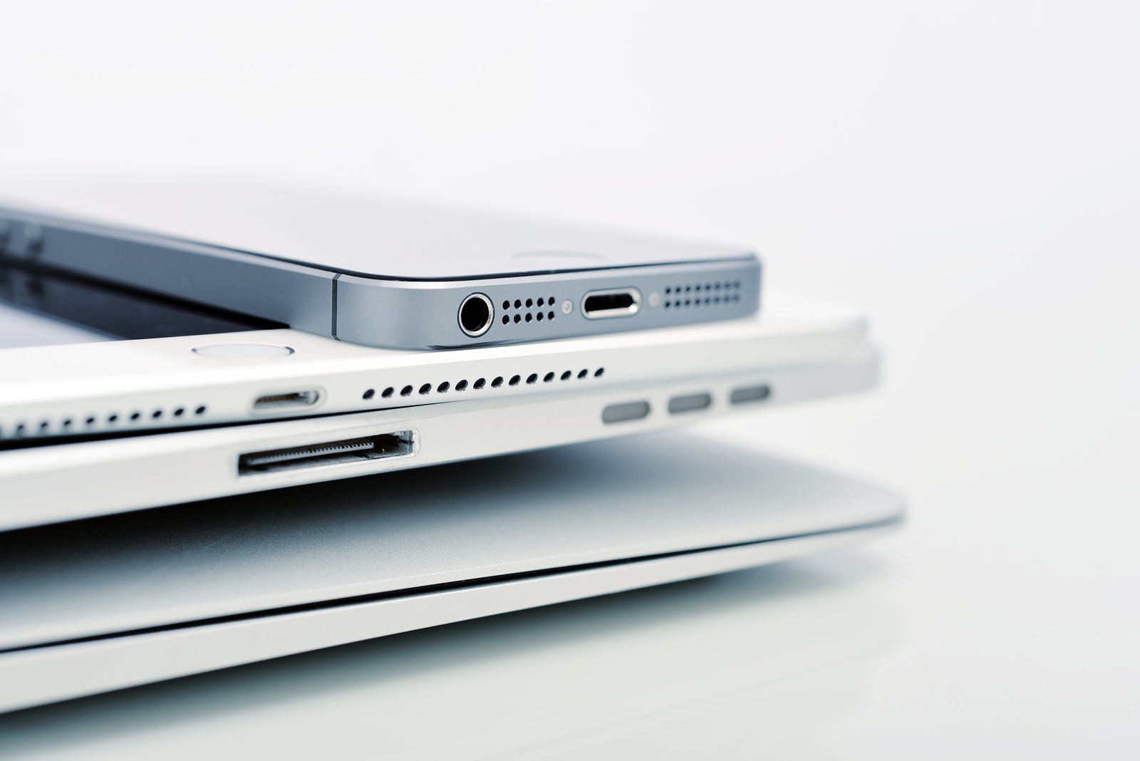KIEV UKRAINE - JANUARY 29 2015: Pile of Apple iPhone 5s iPad Air 2 and MacBook Air . Apple Inc. is an American multinational corporation that designs, develops and sells consumer electronics.