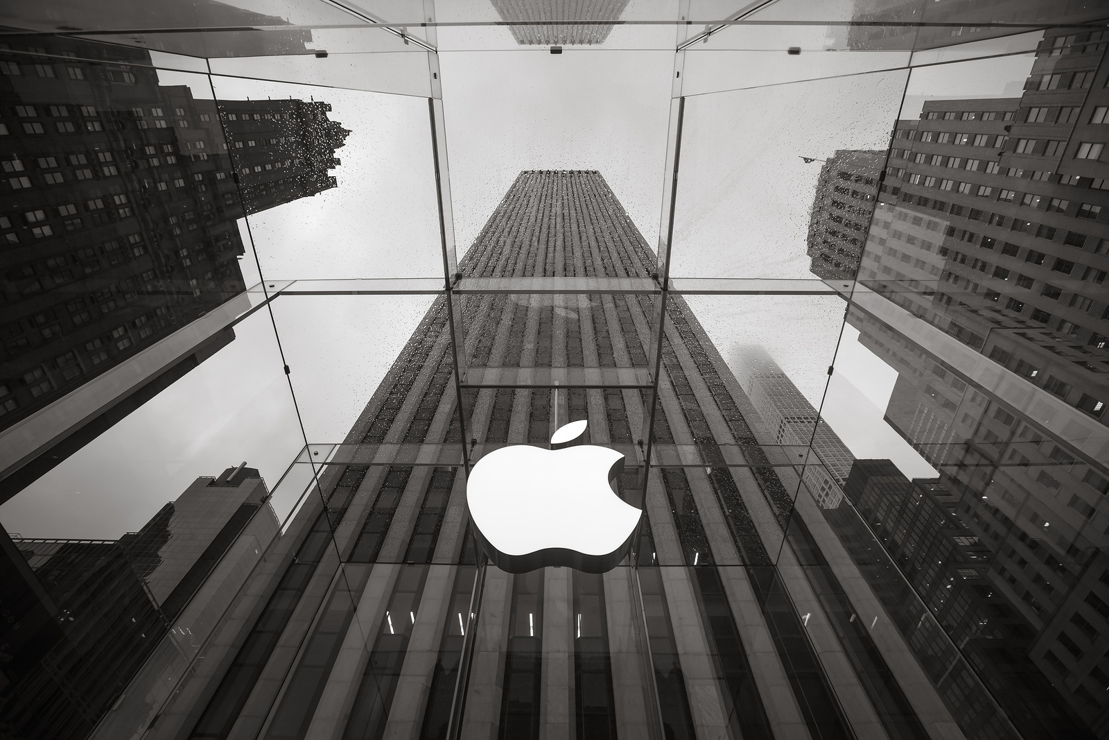 NEW YORK USA - May 04 2016: Apple Store logo at the entrance to the Apple Store on Fifth Avenue New York. Apple Store cube on 5th Avenue on a cloudy rainy day