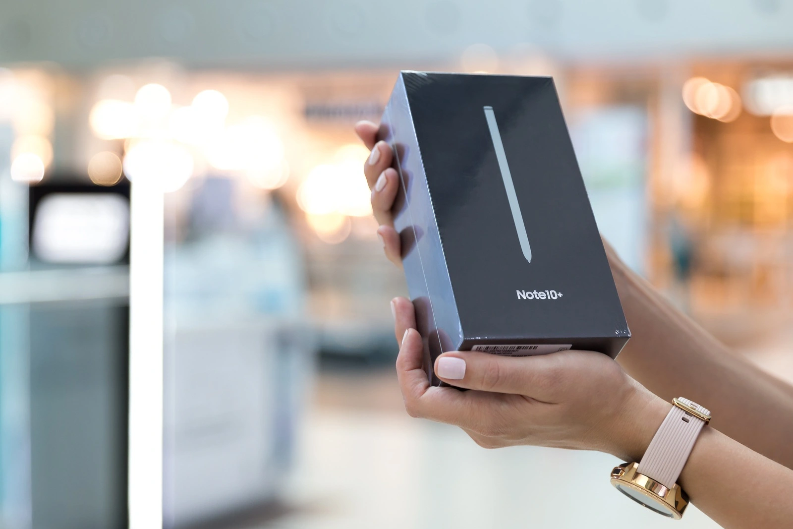 Belgrade, Serbia - August 23, 2019: New smartphone, Samsung Galaxy Note 10+ is displayed in original cardboard box, held in hands against isolated blurry background