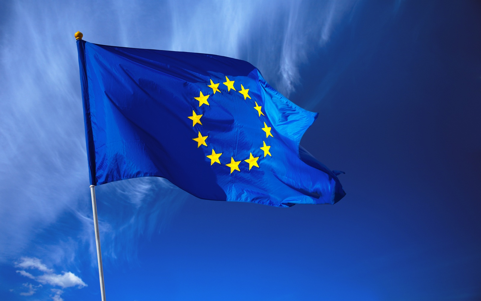 Flag of the European Union in front of the deep blue sky.