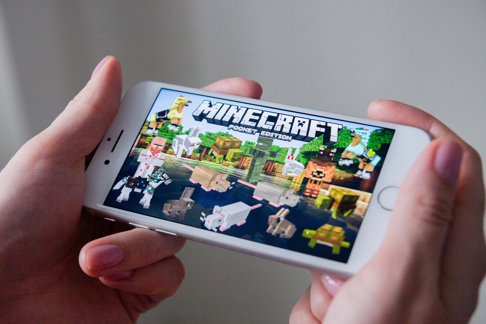 Los Angeles, California, USA - March 8, 2019: Hands holding a smartphone with Minecraft Pocket Edition game on display screen, Illustrative Editorial