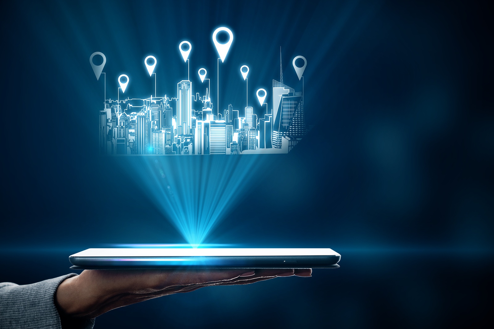 Close up of hand holding tablet with city hologram and location pins on blurry background with bokeh circles. Map and innovation concept