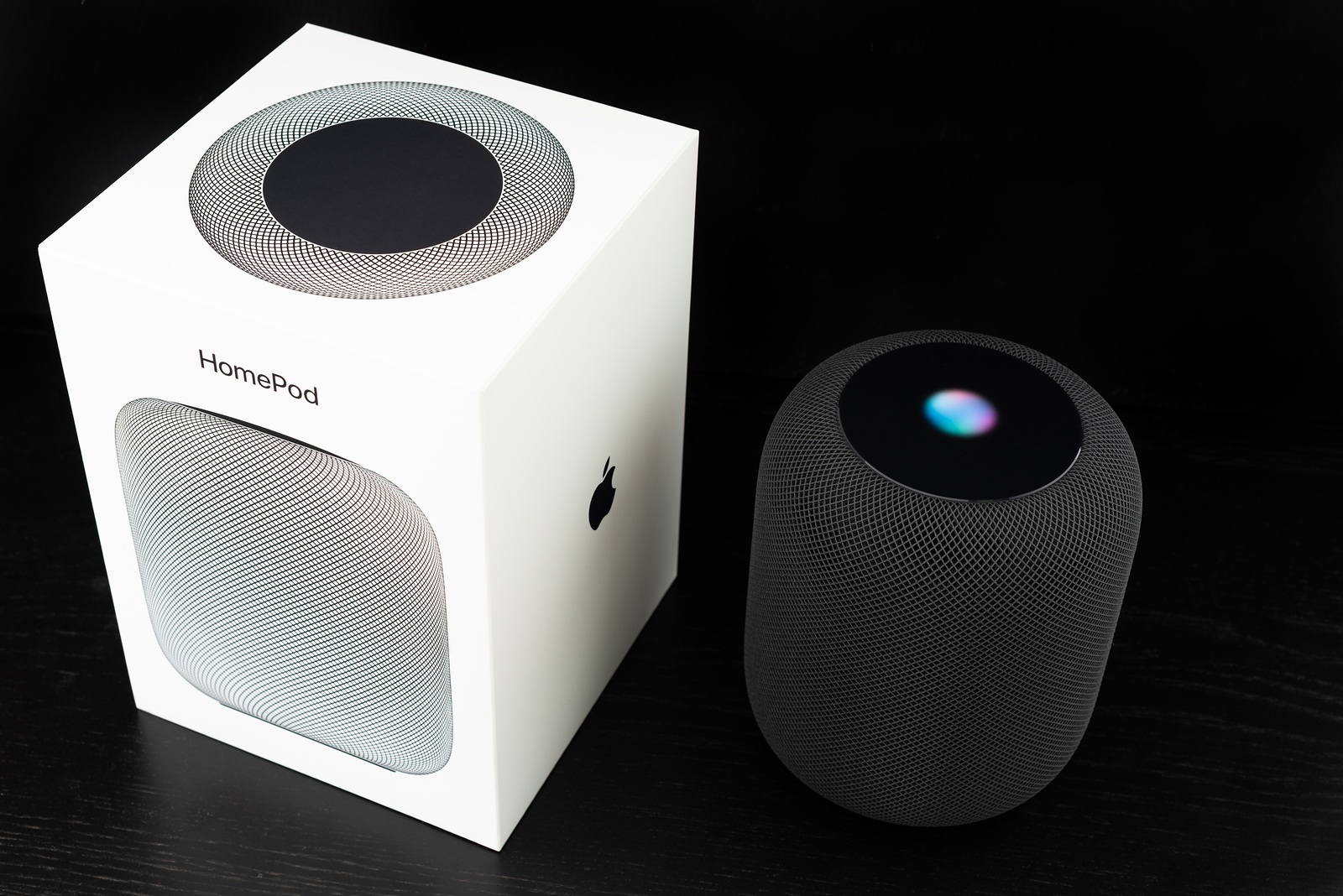 Ostfildern, Germany - June 26, 2018: Unboxing an Apple HomePod speaker: The speaker is standing next to its iconic box, ready to receive voice commands.