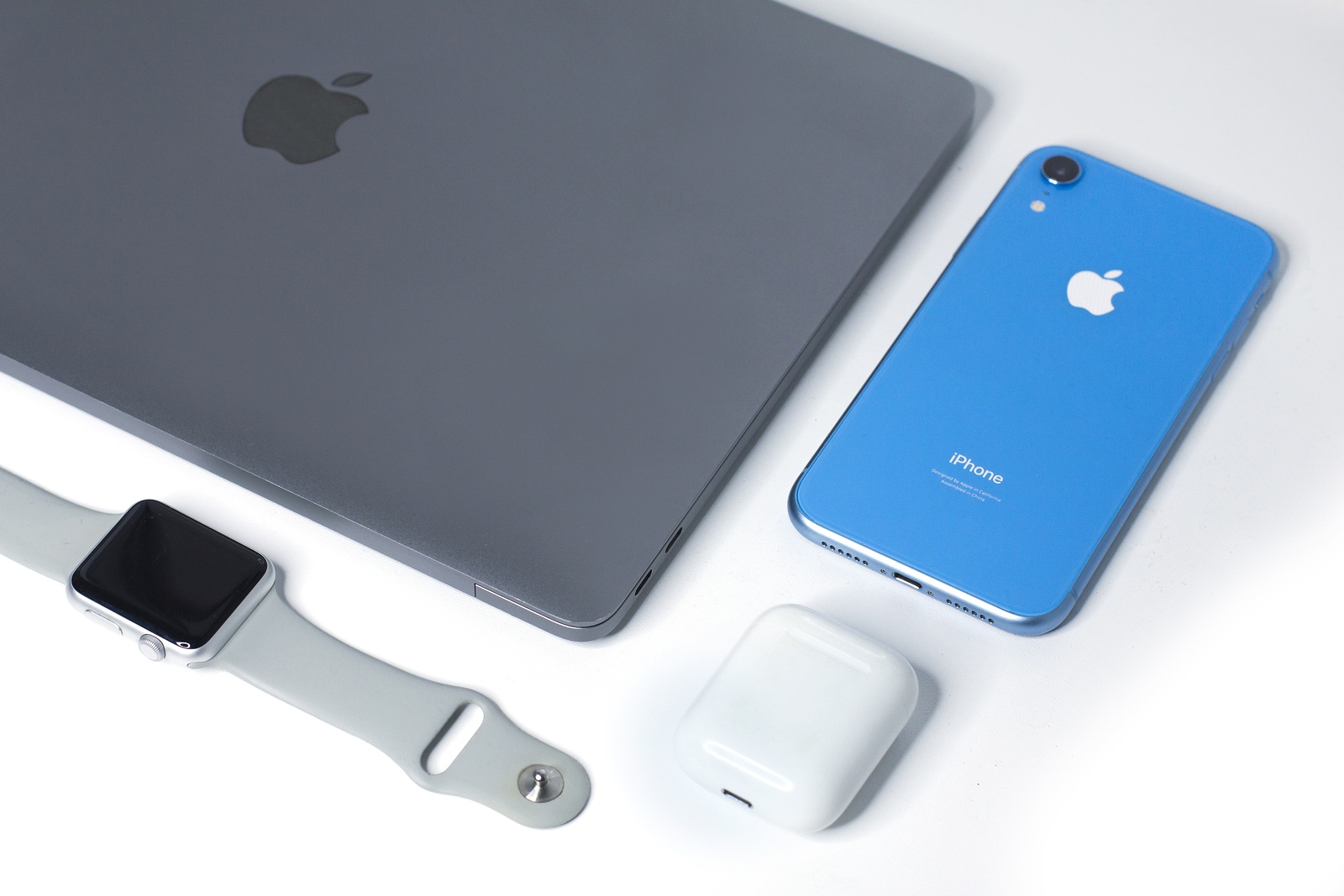 Saint-Petersburg/Russia - September 9, 2019: Still life, composition of new Apple gadgets, devices: Blue iPhone XR, wireless earphones Airpods, Apple Watch sport and MacBook Pro, Air space gray. Flat lay set