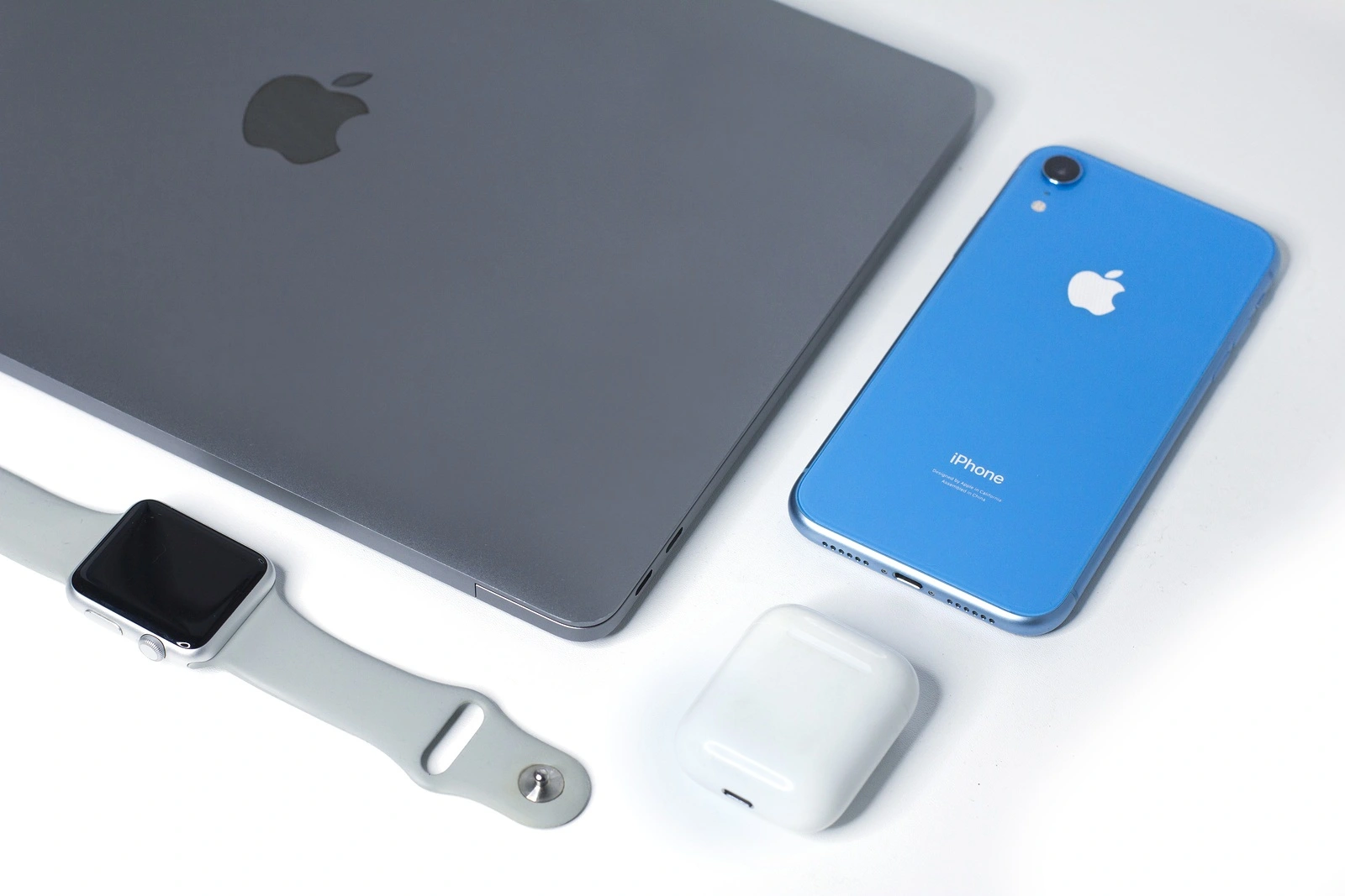 Saint-Petersburg/Russia - September 9, 2019: Still life, composition of new Apple gadgets, devices: Blue iPhone XR, wireless earphones Airpods, Apple Watch sport and MacBook Pro, Air space gray. Flat lay set