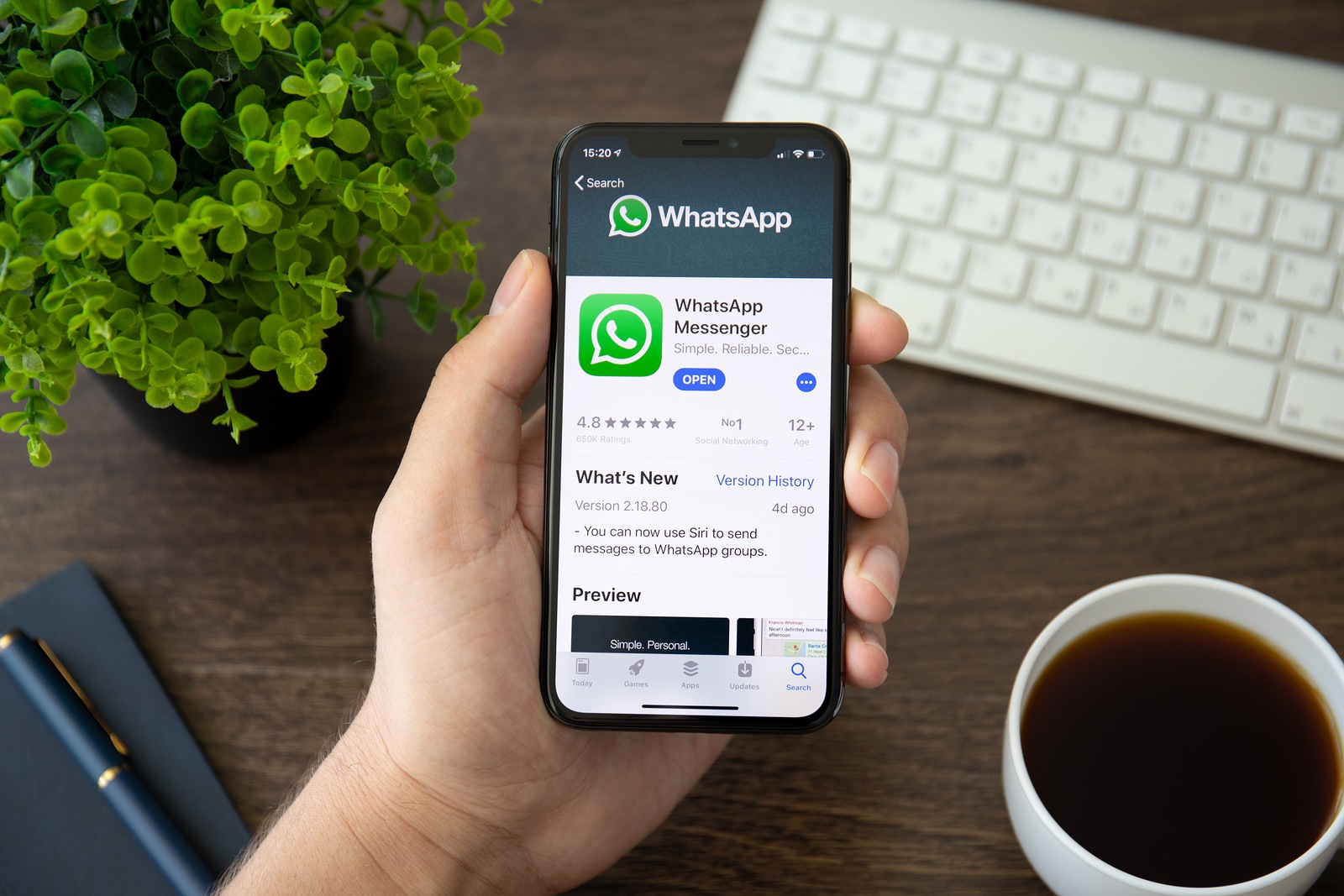 Alushta, Russia - July 30, 2018: Man holding iPhone X with social networking service WhatsApp on the screen. iPhone 10 was created and developed by the Apple inc.