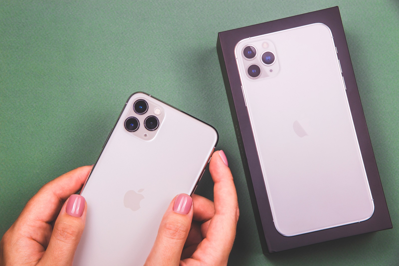 Kiev, Ukraine - November 13, 2019: Kiev, Ukraine - November 13, 2019: new white smartphone Apple Computers iPhone 11 Pro and 11 Pro Max smartphone with three lenses in female hands near the box.