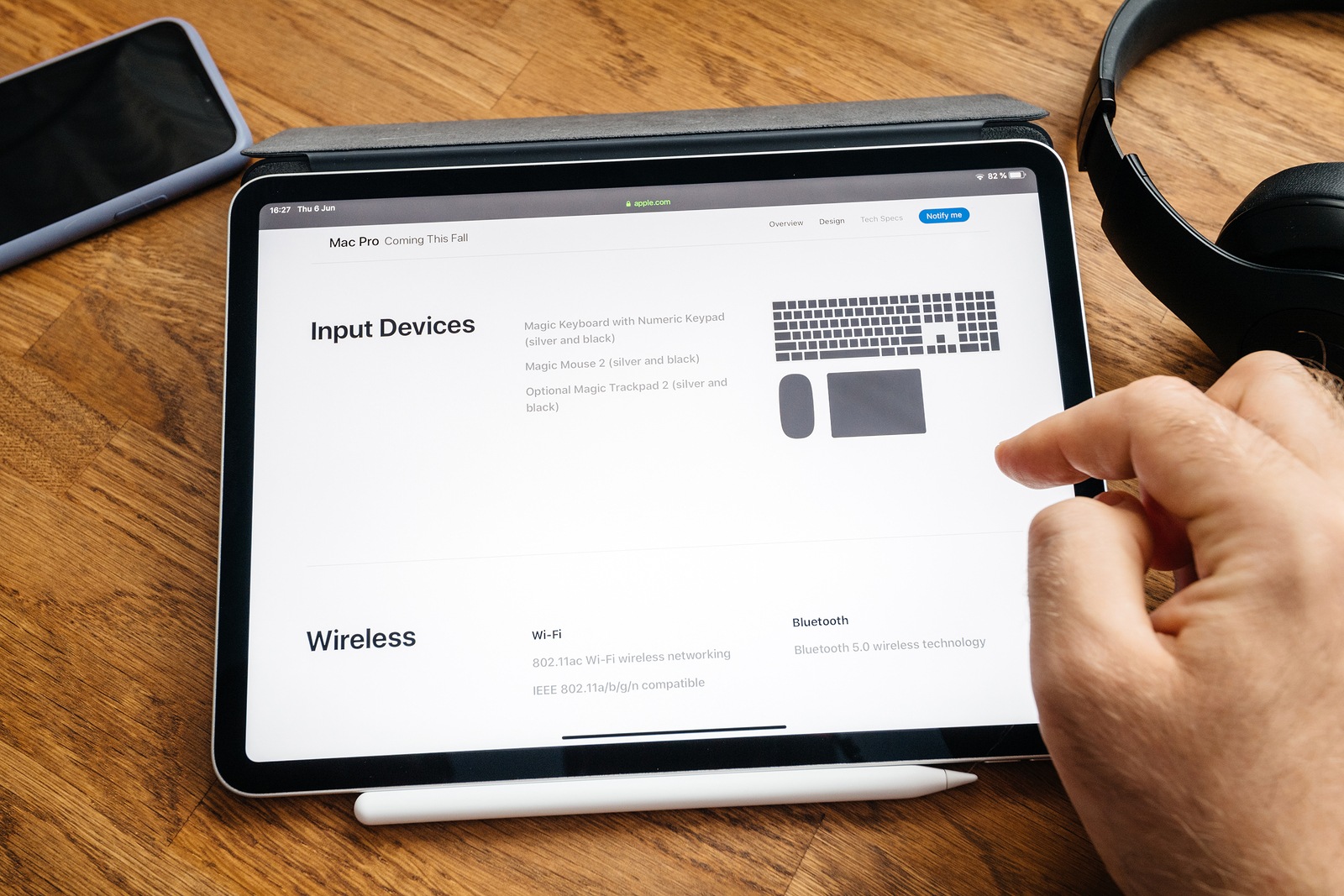 Paris, France - Jun 6, 2019: Man reading on Apple iPad Pro tablet about latest announcement of at Developers Conference WWDC - showing the Mac Pro workstation with accessories and wireless wi-fi