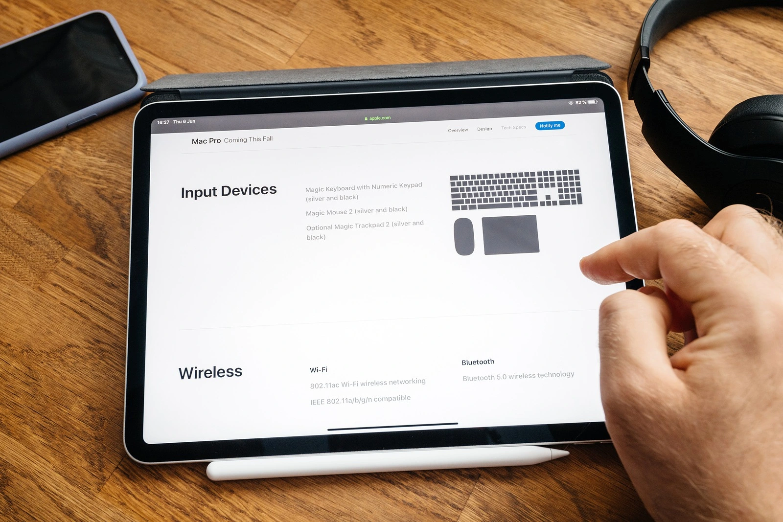 Paris, France - Jun 6, 2019: Man reading on Apple iPad Pro tablet about latest announcement of at Developers Conference WWDC - showing the Mac Pro workstation with accessories and wireless wi-fi