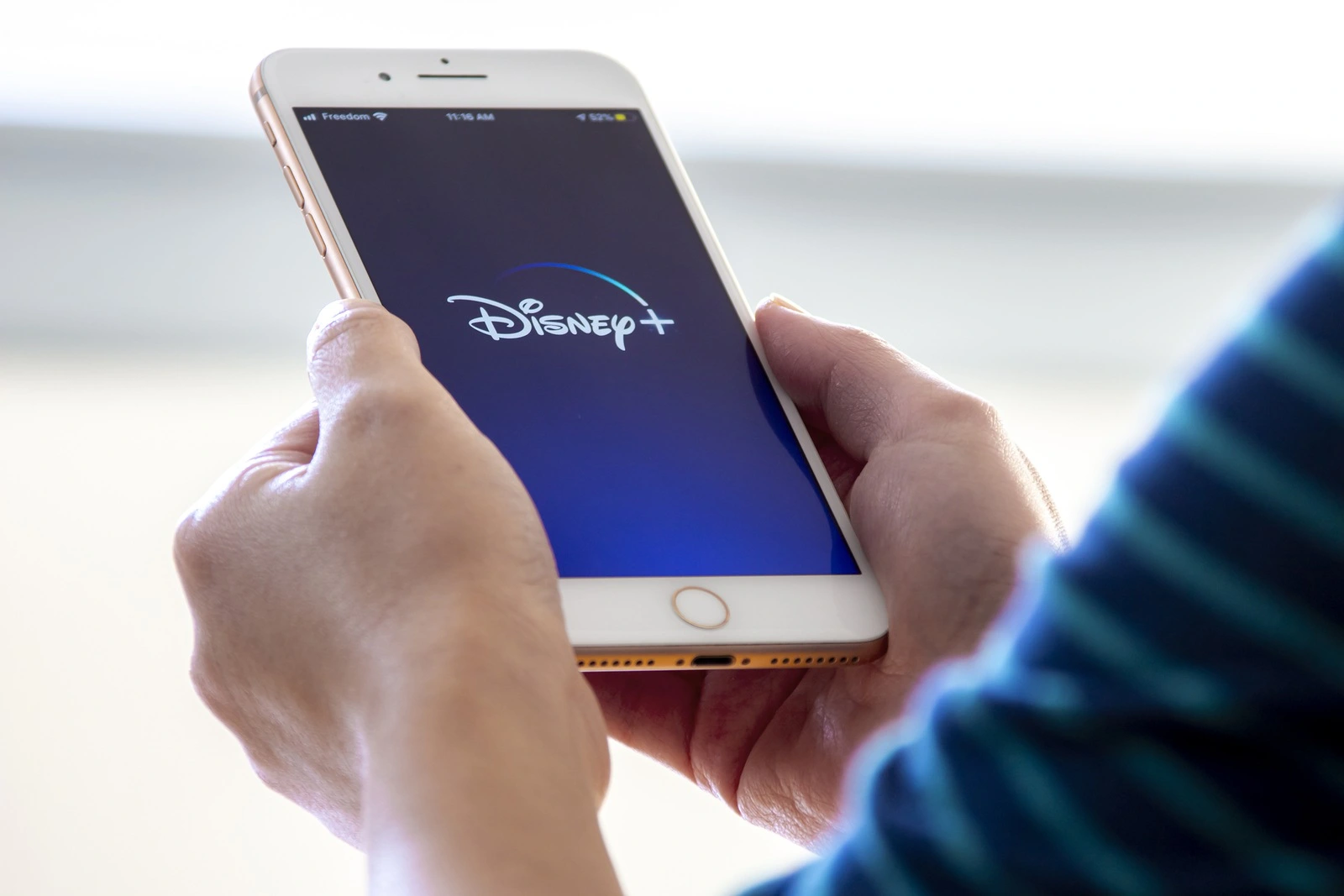 Calgary, Alberta. Canada Nov 28 2019: Woman holds an iPhone plus with the new Disney+ app on her hands. Disney+ releases a new update of its online video streaming service.Illustrative
