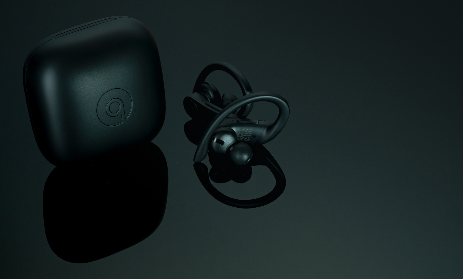 CHONBURI, THAILAND-DECEMBER 26, 2019 : Powerbeats Pro - Totally Wireless Earphones - Black and charging case. Workout headphones on dark background. Apple product. In-ear wireless headphones. Earbuds.