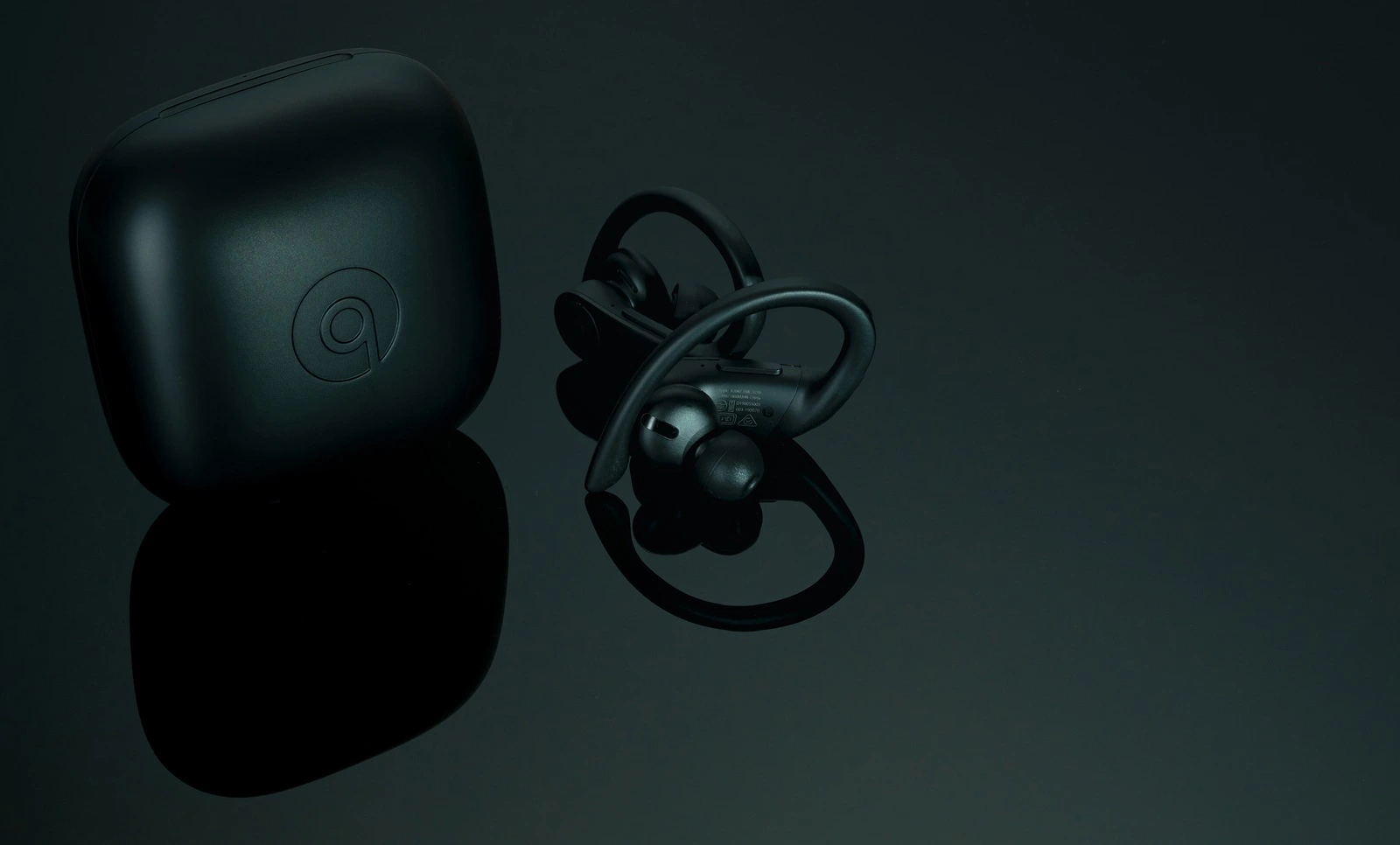 CHONBURI, THAILAND-DECEMBER 26, 2019 : Powerbeats Pro - Totally Wireless Earphones - Black and charging case. Workout headphones on dark background. Apple product. In-ear wireless headphones. Earbuds.