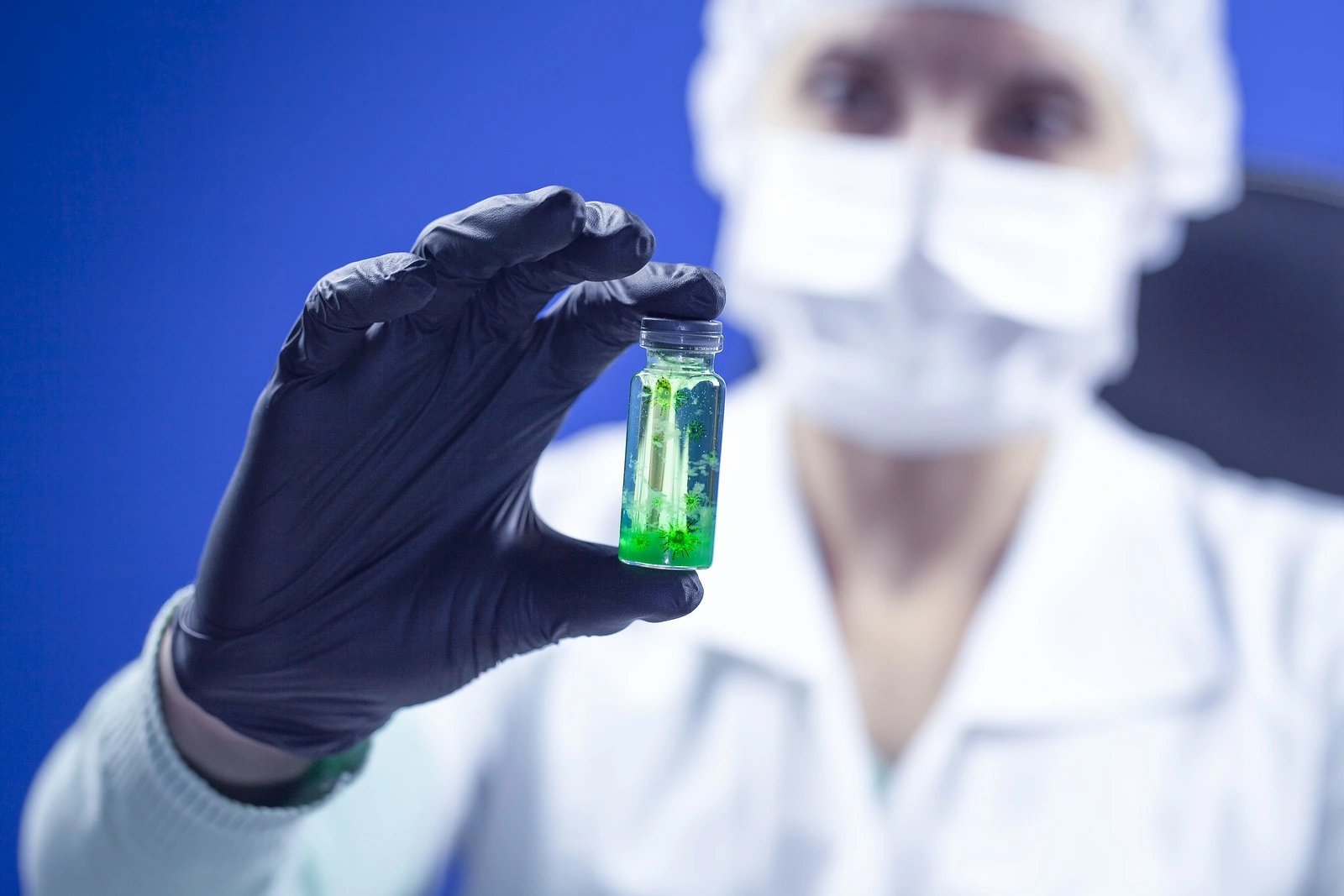Concept of coronavirus quarantine. MERS-Cov (middle East respiratory syndrome coronavirus), Novel coronavirus (2019-nCoV), test tube with coronovirus in the hands of a virologist in a chemical laboratory, blue tinted