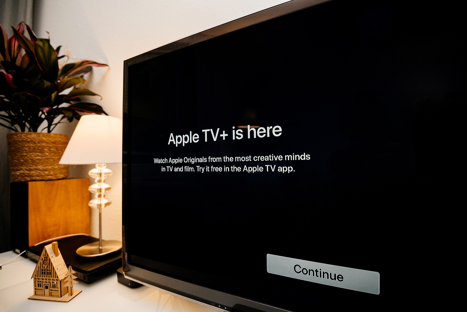 Paris, France - Nov 1, 2019: Side view of Apple TV plus is here message on living room display with try for free continue button - wide Panasonic plasma OLED tv set
