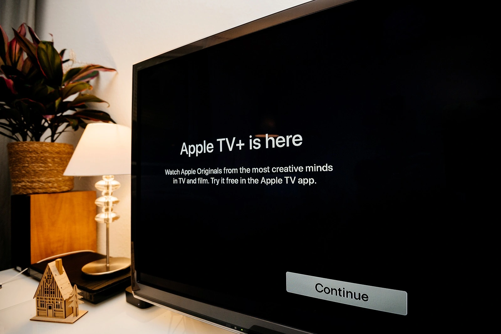 Paris, France - Nov 1, 2019: Side view of Apple TV plus is here message on living room display with try for free continue button - wide Panasonic plasma OLED tv set
