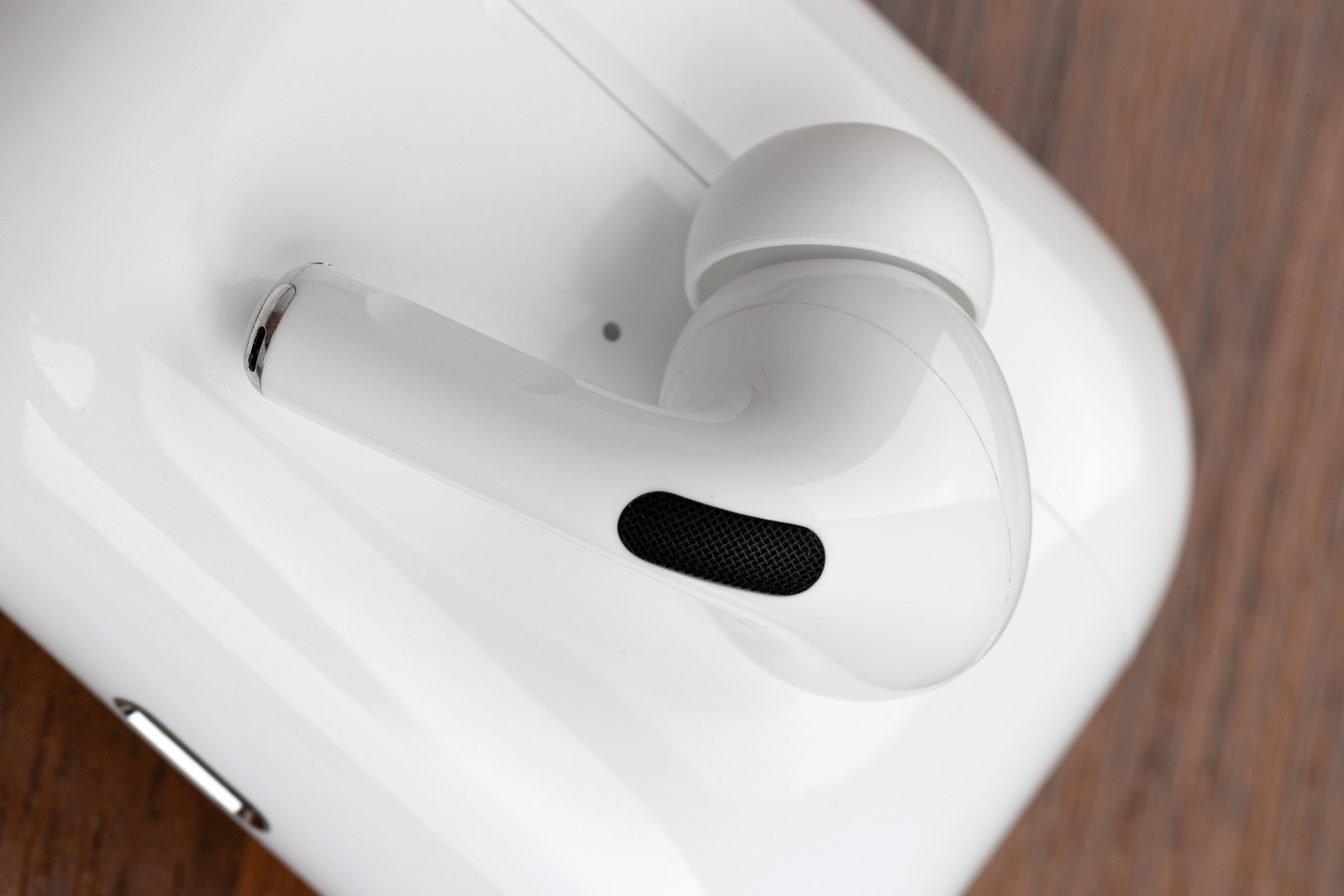 Rostov-on-Don, Russia - December 2019. Apple AirPods Pro on a wooden table. Wireless headphones and charging case close-up.
