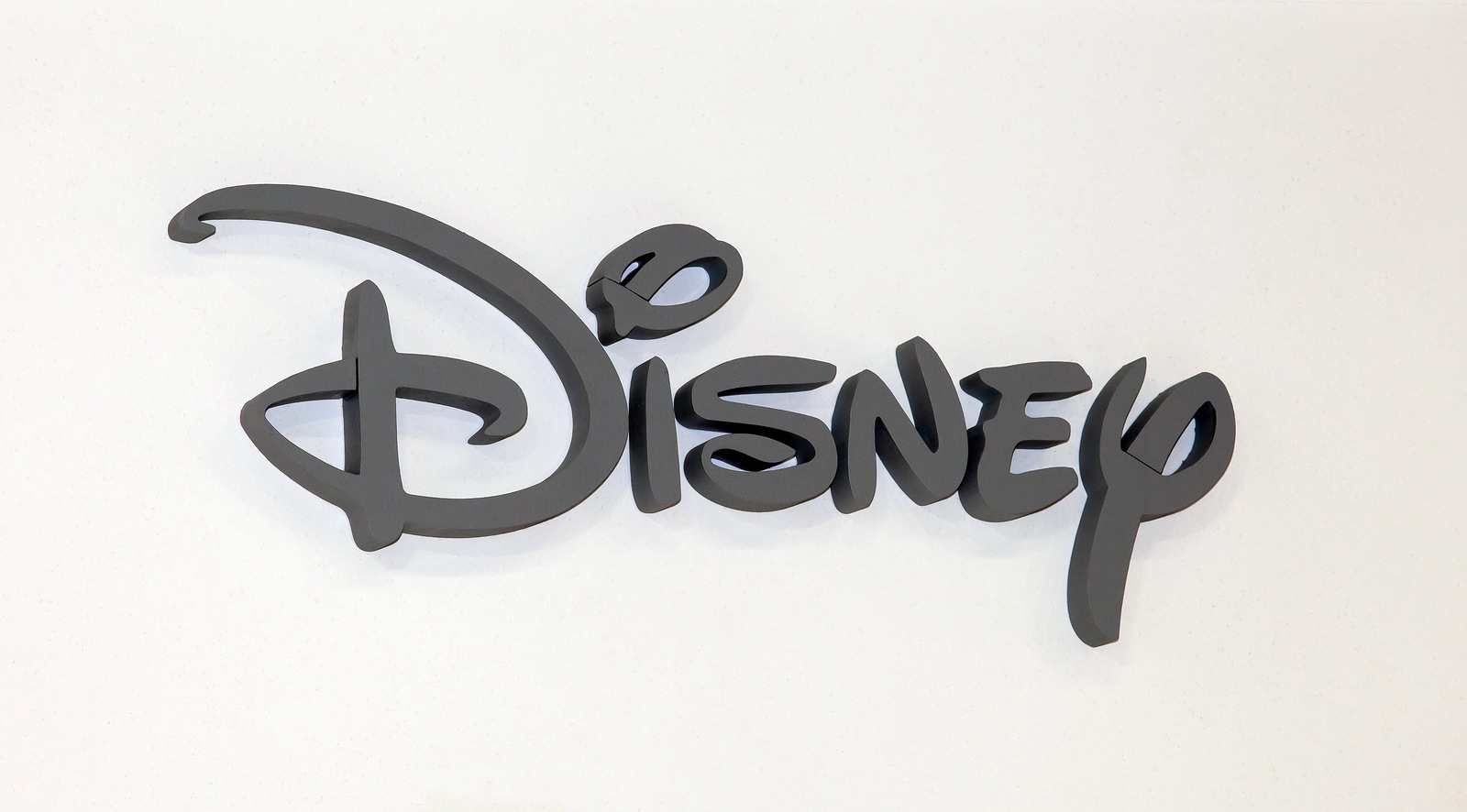 Moscow, Russia - March, 2015: Disney company logo sign. Gray plastic letters on the white wall