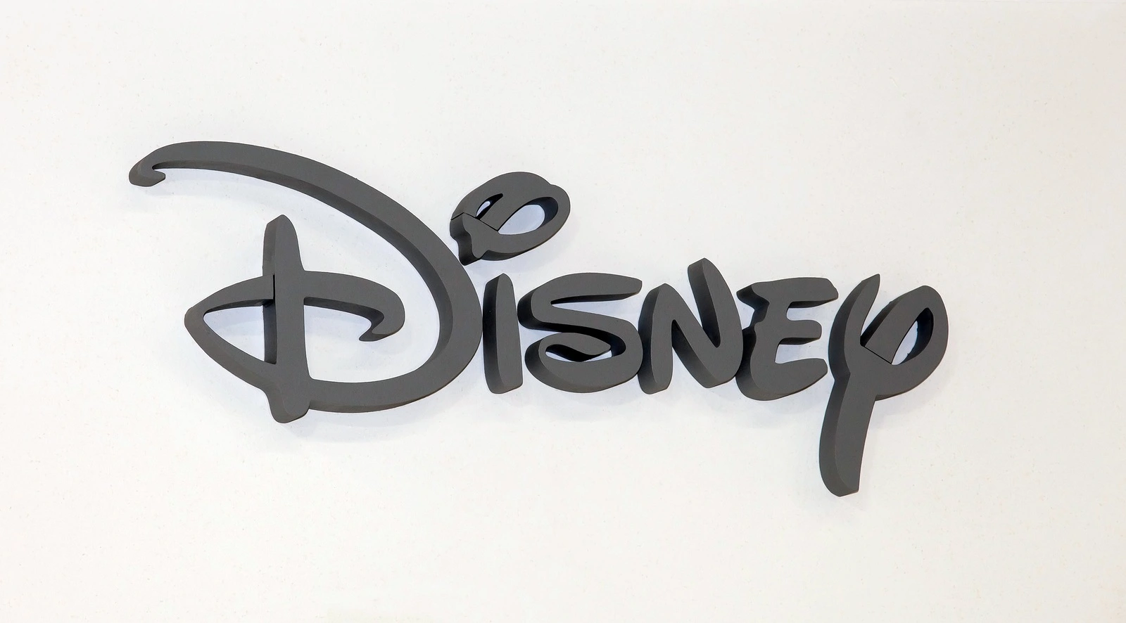 Moscow, Russia - March, 2015: Disney company logo sign. Gray plastic letters on the white wall