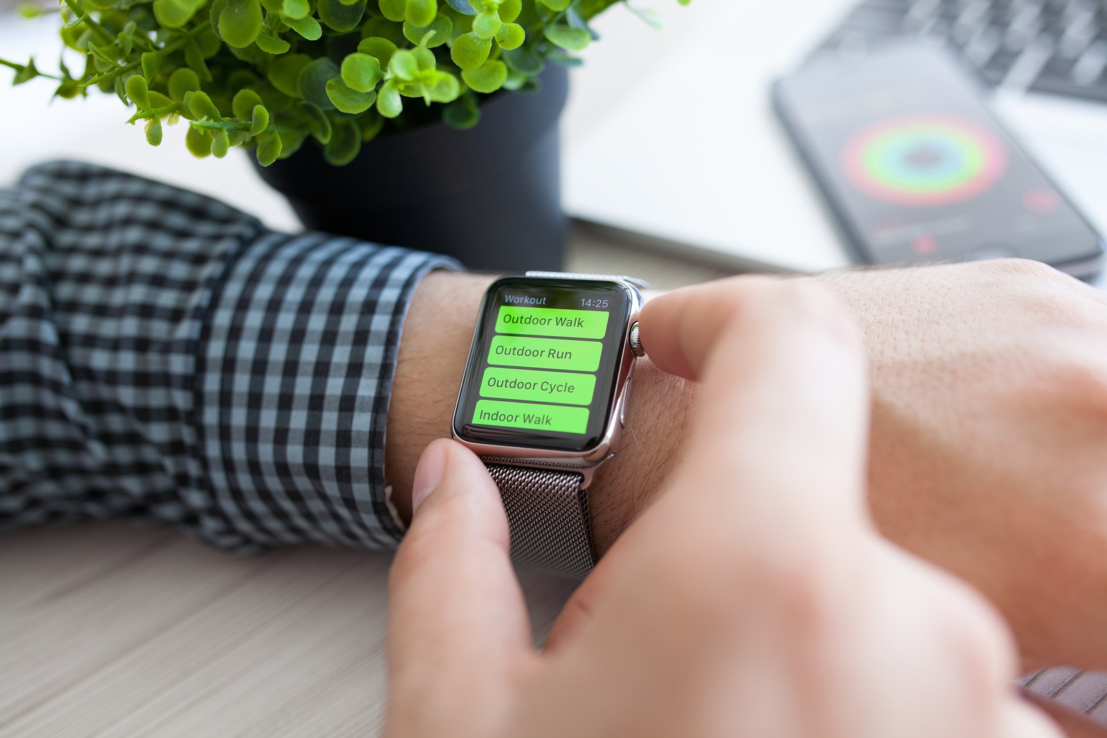 Alushta Russia - August 14 2015: Man hand with Apple Watch and app Workout on the screen. Apple Watch was created and developed by the Apple inc.** Note: Shallow depth of field