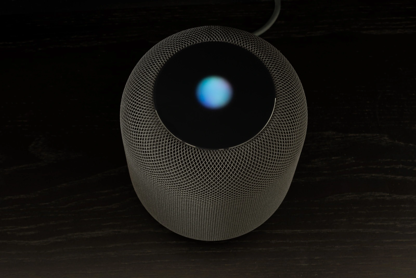 Ostfildern, Germany - June 26, 2018: Using an Apple HomePod speaker - the smart speaker is reacting to voice input and signaling its attention by the changing lights