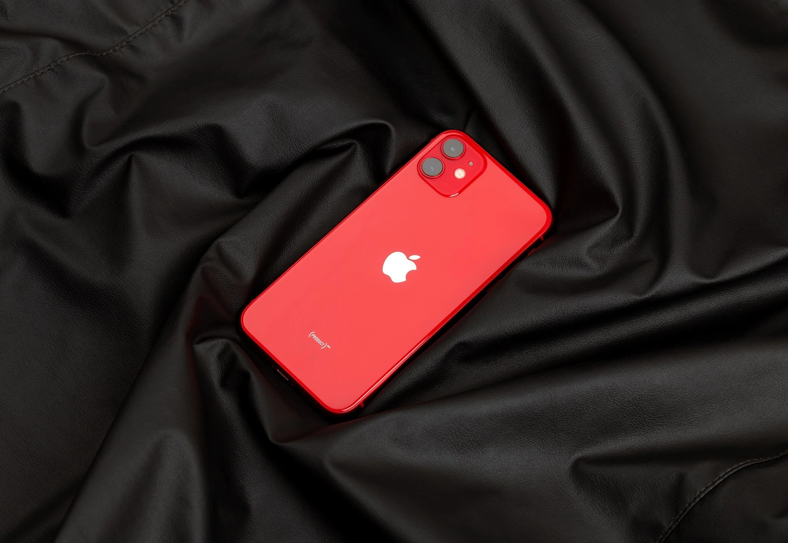 Rostov-on-Don, Russia - December 2019. Apple iPhone 11 PRODUCT RED on a black leather surface. New smartphone from the company Apple close-up.