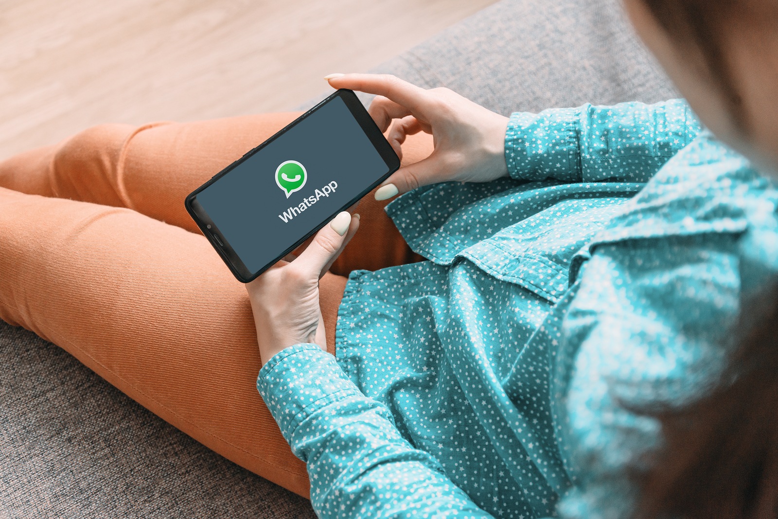 Gelendzhik, Russia, November 19, 2019: Young woman using WhatsApp on her cellphone at home.