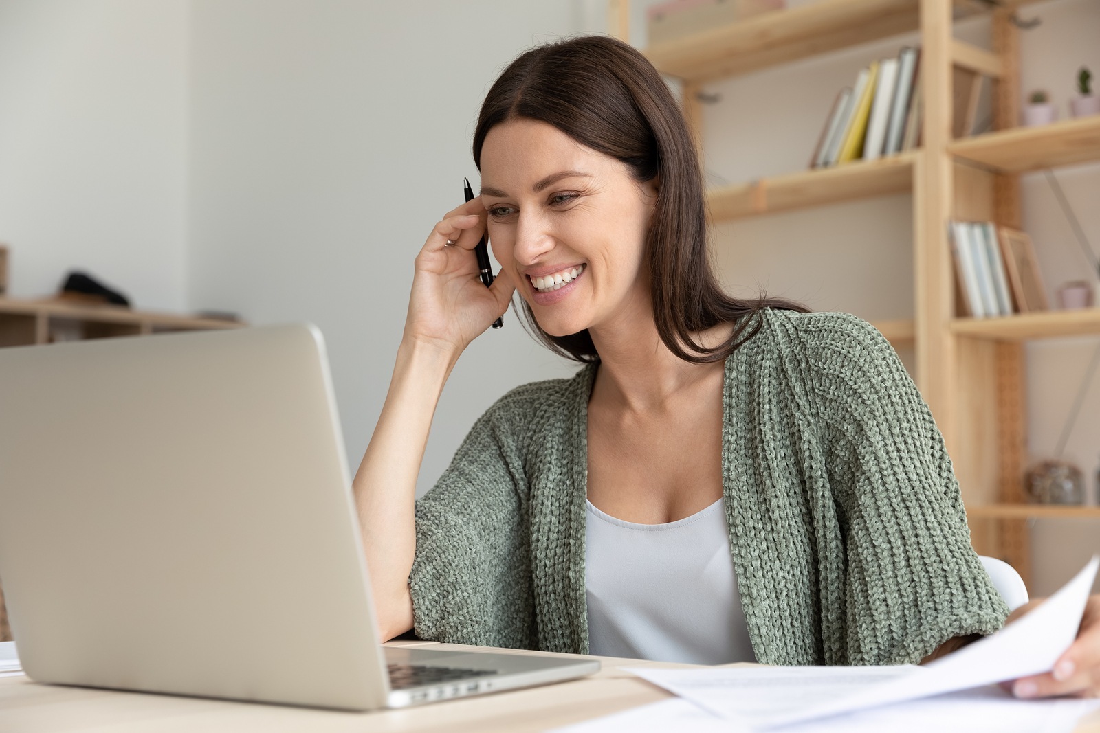 Smiling female employee laugh watching webinar on laptop