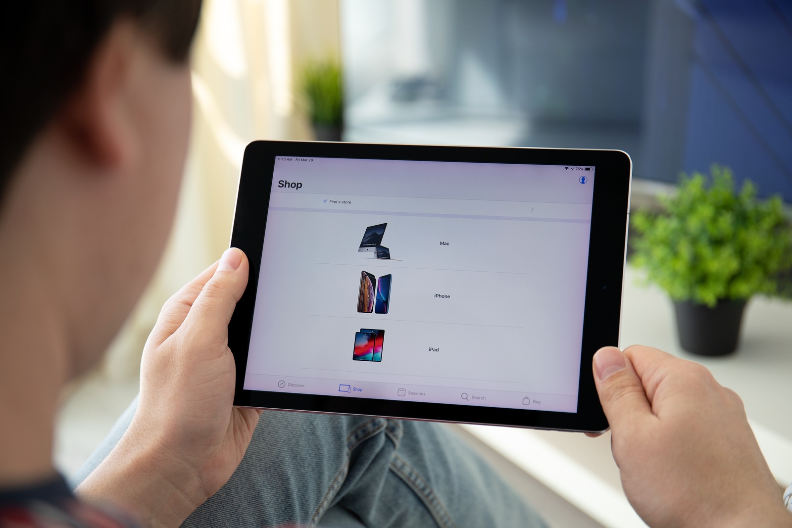 Anapa, Russia - March 29, 2019: Man hands holding iPad Pro with Apple Store app on the screen. iPad Pro was created and developed by the Apple inc.