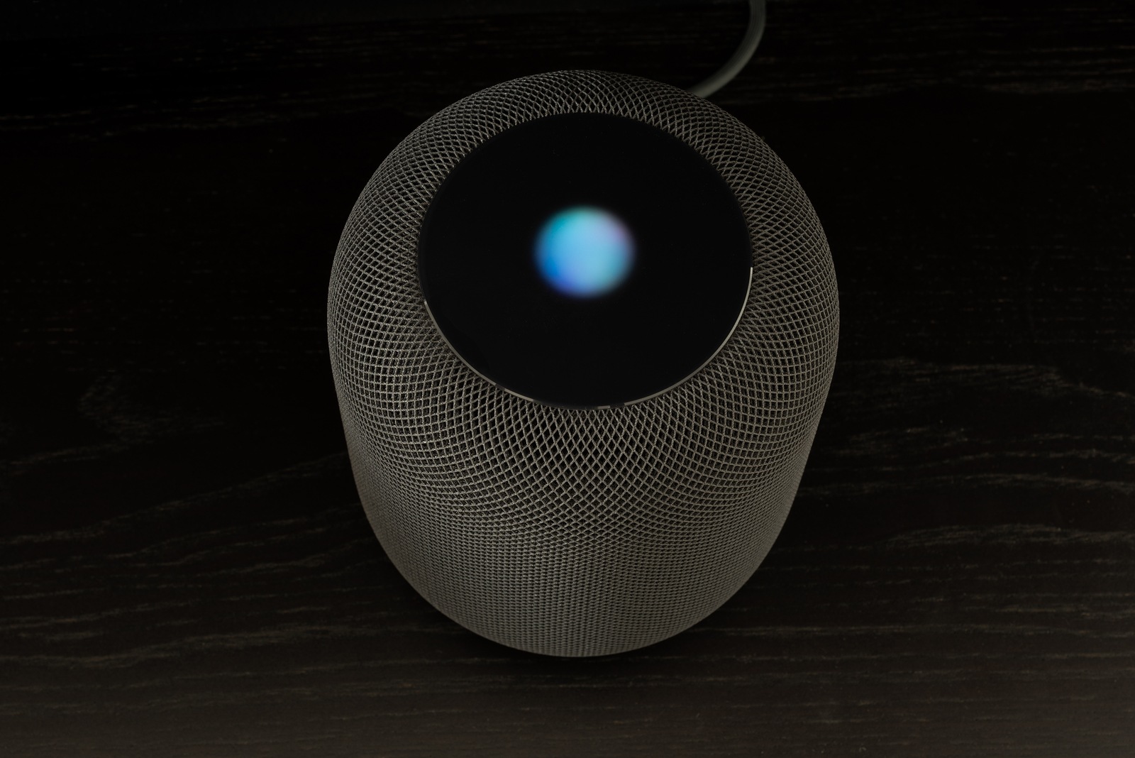 Ostfildern, Germany - June 26, 2018: Using an Apple HomePod speaker - the smart speaker is reacting to voice input and signaling its attention by the changing lights