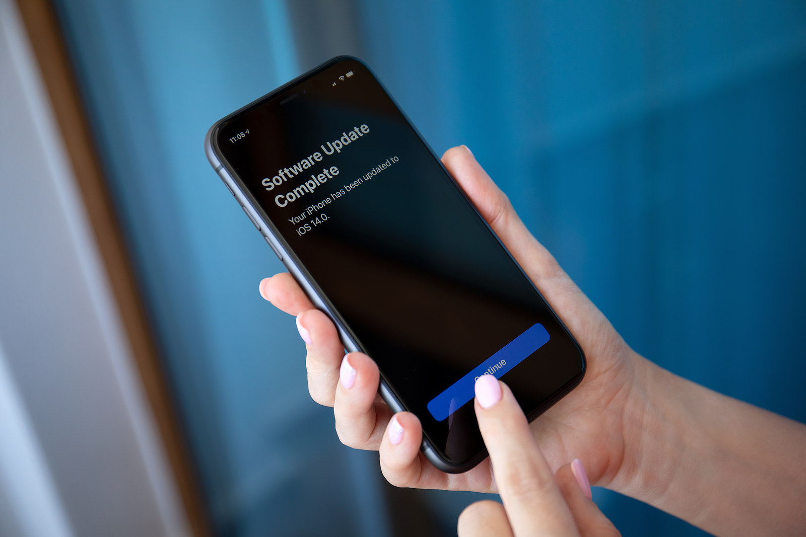 Alanya, Turkey - July 10, 2020: Woman hand holding iPhone 11 with software update IOS 14 on the screen. iPhone 11 was created and developed by the Apple inc.