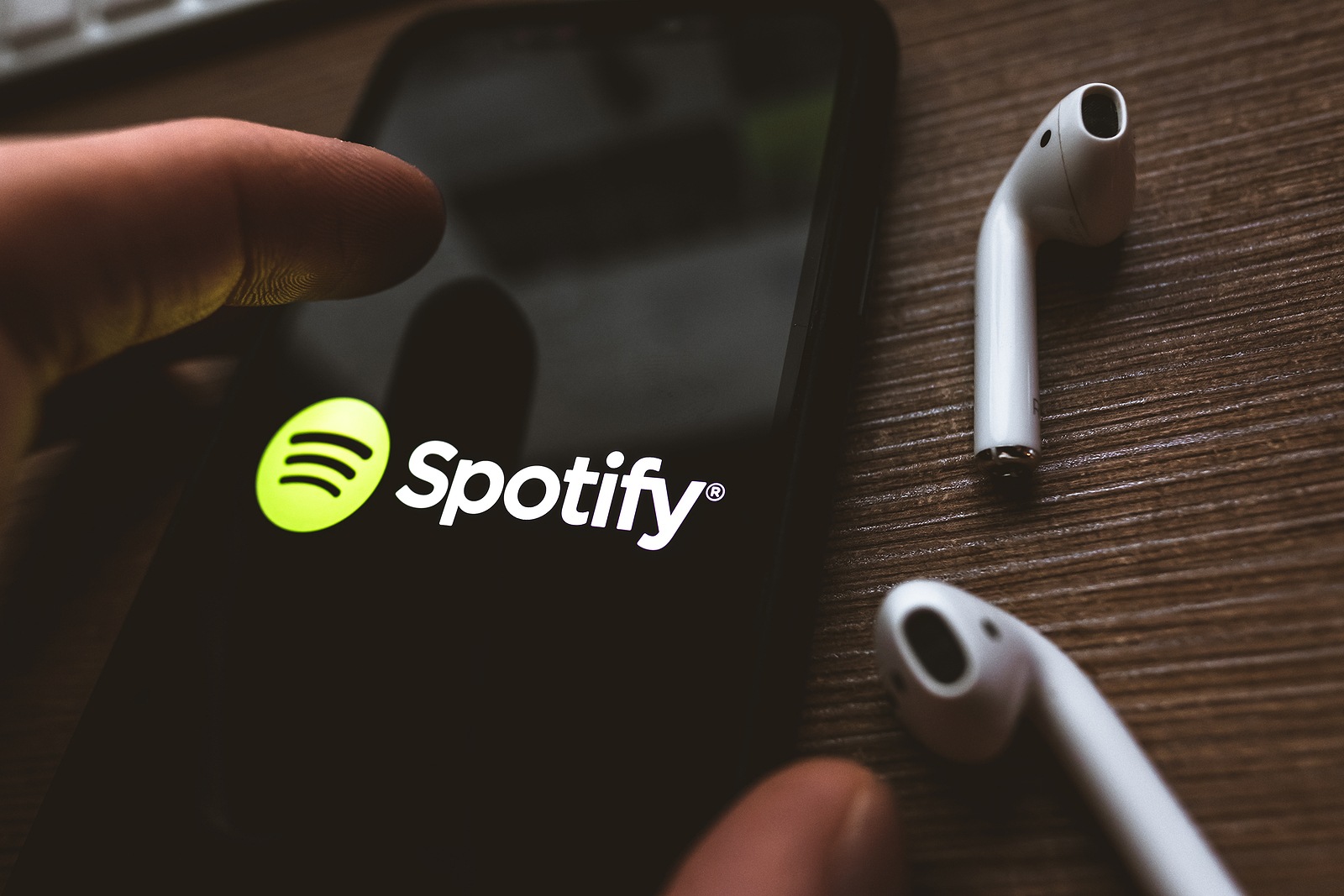 iPhone X and AirPods with screen shot of Spotify app. High quality photo.