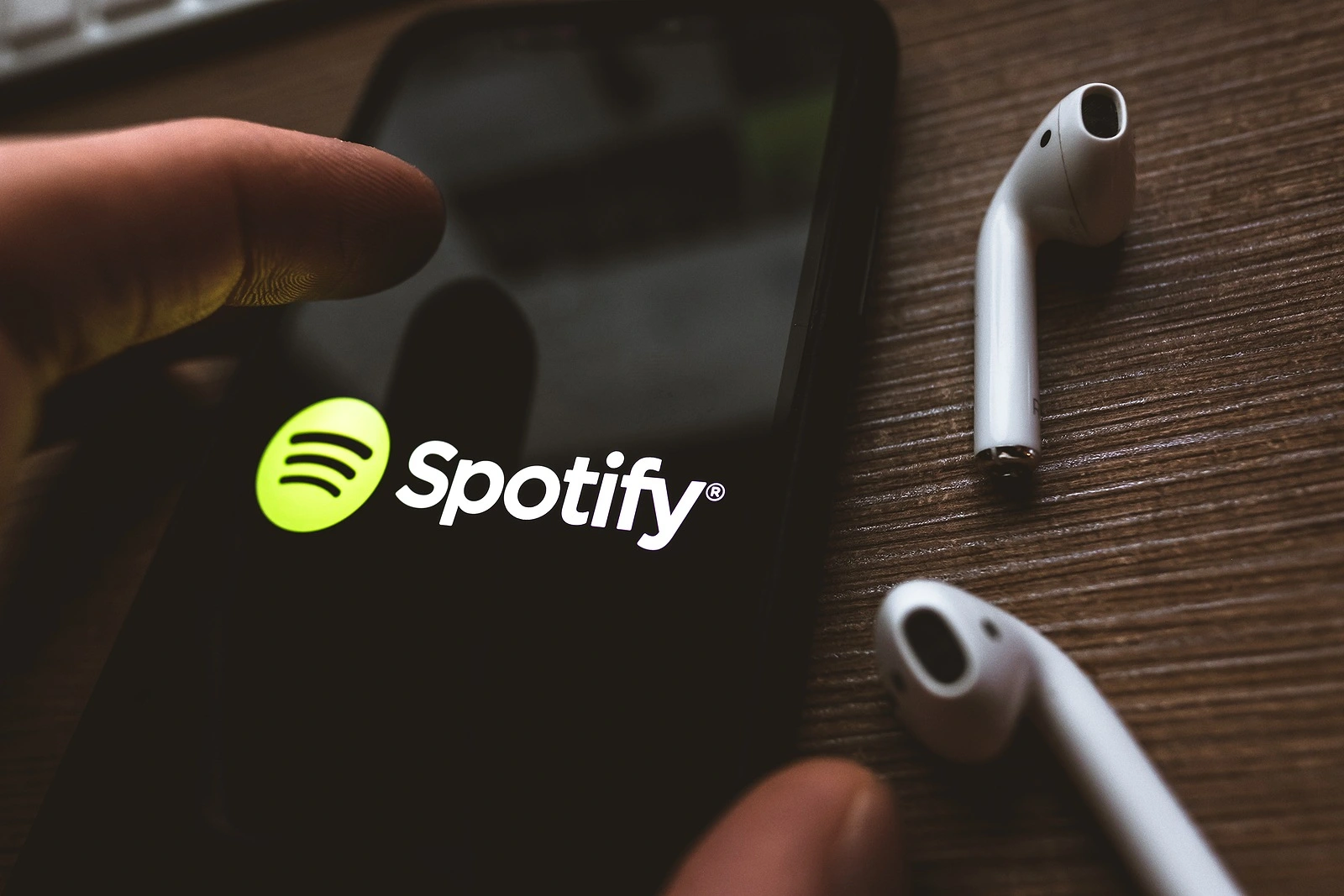 iPhone X and AirPods with screen shot of Spotify app. High quality photo.