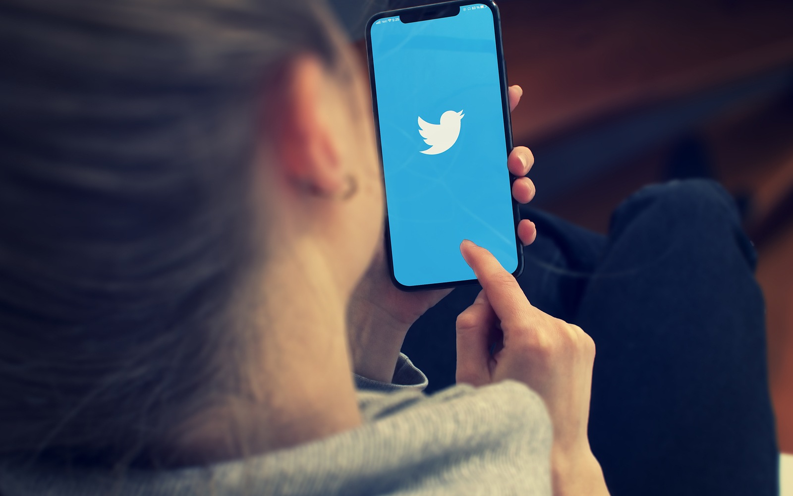 KYIV, UKRAINE-JANUARY, 2020: Twitter on smartphone screen. Young Girl Pointing or Texting Twitter on Smart Phone.
