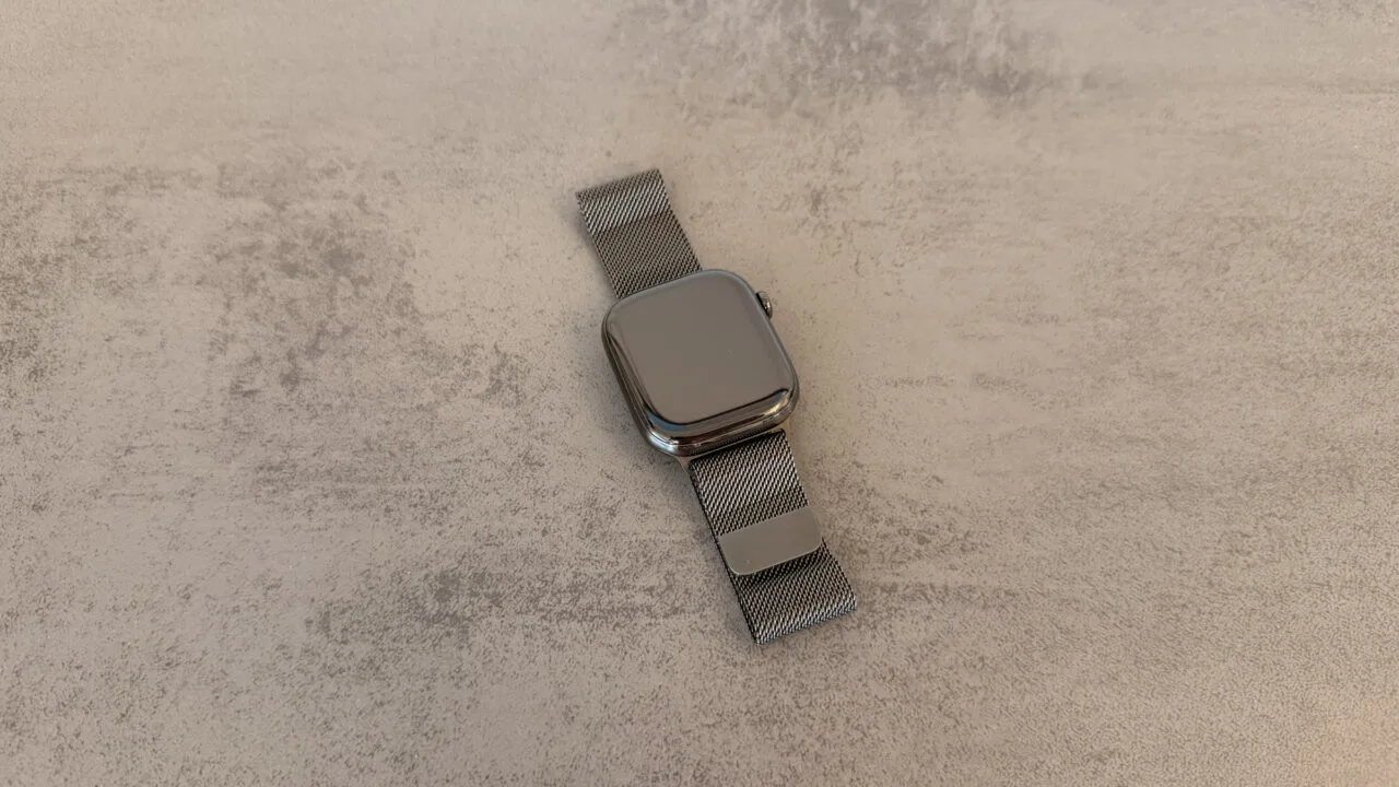 Apple Watch with a Milanese loop lying on light stone with a dark display, the starting point for an Apple Watch restart
