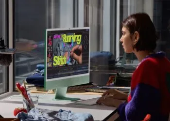Video editing on a green iMac: a woman works on a sewing video, a typical use case for the iMac M6