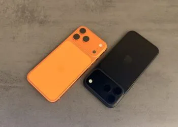 Selling an iPhone safely: two iPhones lying face down on a grey surface, one orange and one black