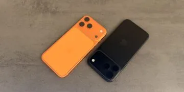 Selling an iPhone safely: two iPhones lying face down on a grey surface, one orange and one black