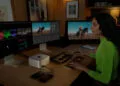 Workstation with Mac Studio and three external displays, a person editing video at keyboard and color grading panel