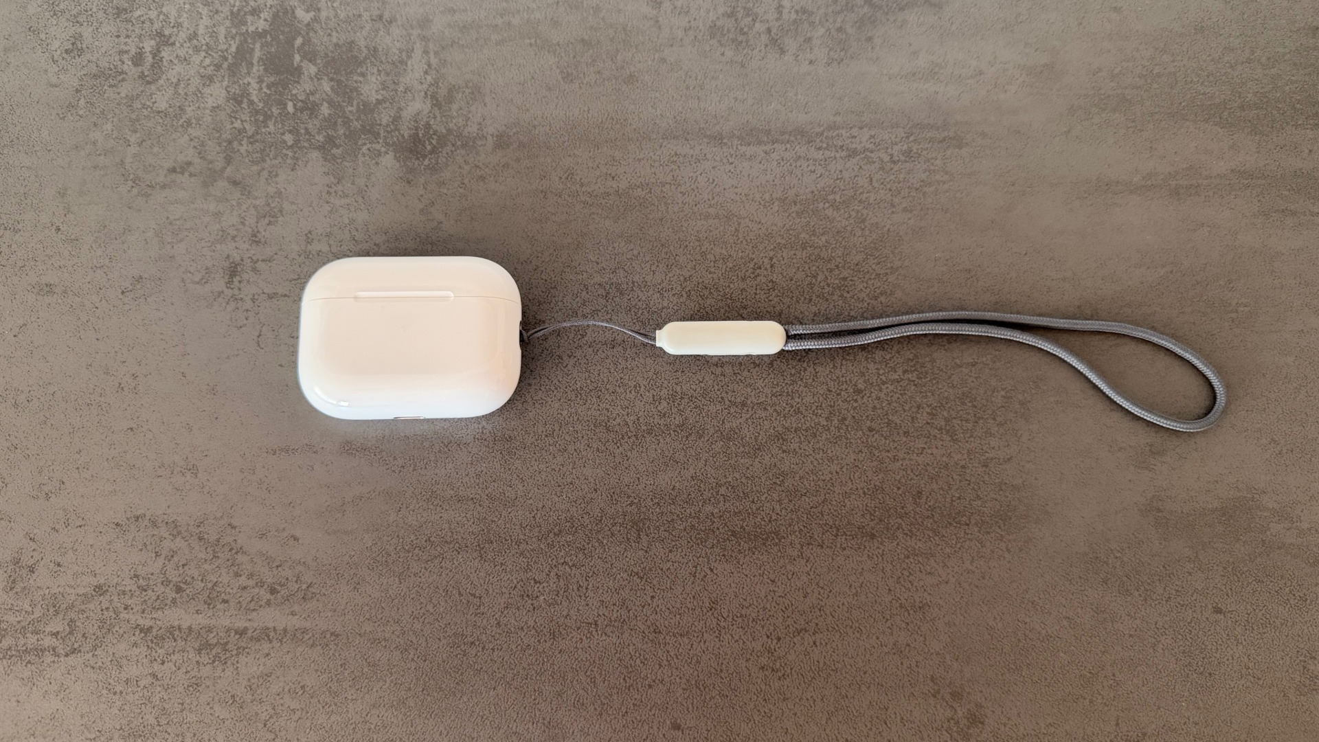 AirPods Pro 3 in white with closed charging case against a dark background