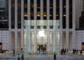 Symbolic image for Apple government affairs: the glass entrance cube of the Apple Store on Fifth Avenue in New York at dusk