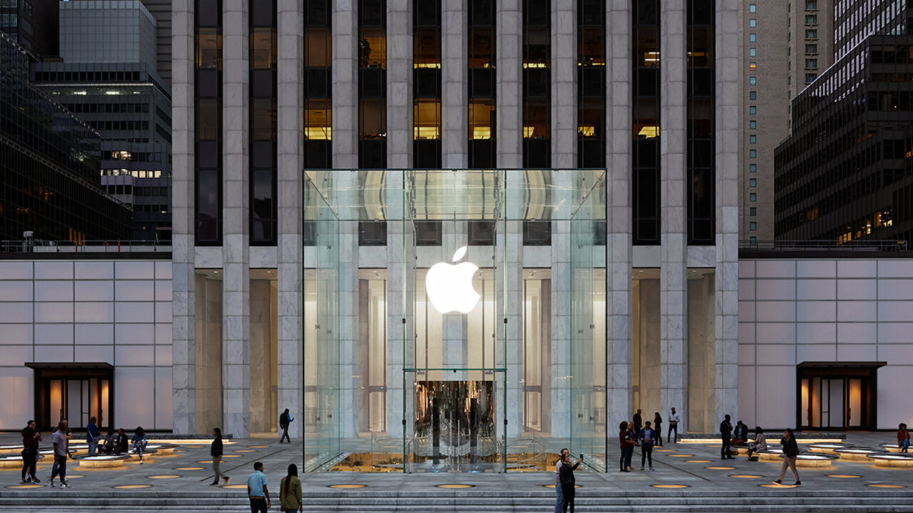 Symbolic image for Apple government affairs: the glass entrance cube of the Apple Store on Fifth Avenue in New York at dusk